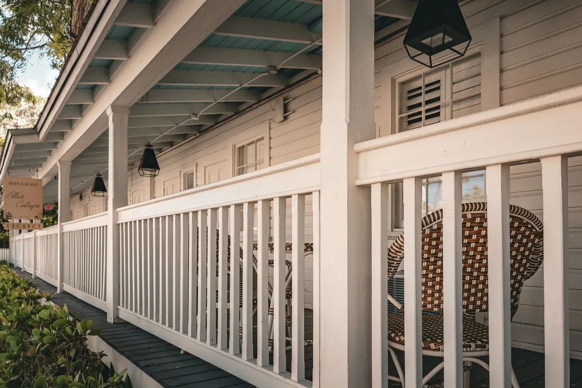 Cozy porch with wicker chairs and lanterns, perfect for creating a welcoming atmosphere when selling a home.