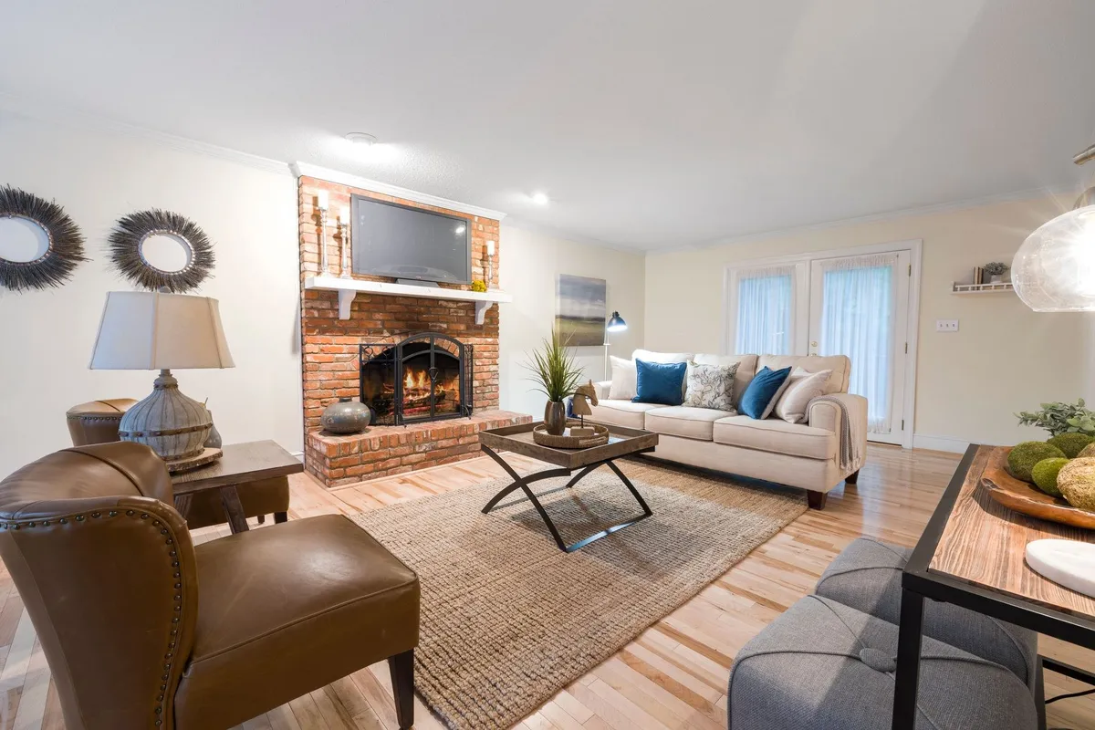 Cozy living room with comfortable seating and a brick fireplace, perfect for staging a home for sale.